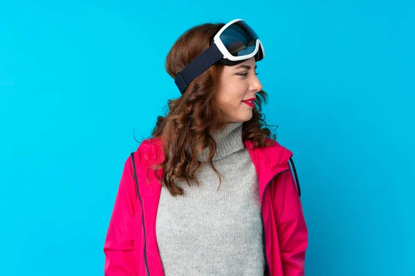 Skier Kobieta Okularach Snowboardowych Odizolowanej Niebieskiej Ścianie Patrząc Bok — Zdjęcie stockowe