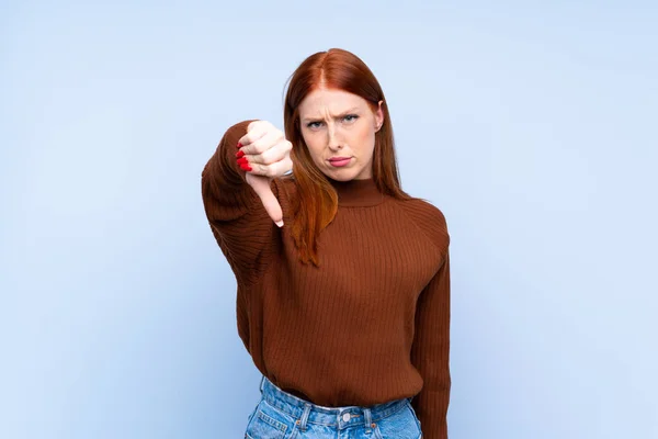 Zole Edilmiş Mavi Arka Planda Genç Kızıl Saçlı Kadın Olumsuz — Stok fotoğraf