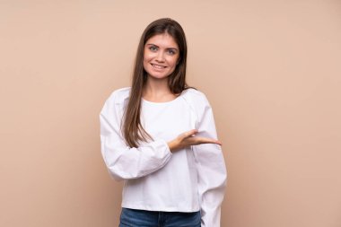 İzole edilmiş arka planda genç bir kız gülümseyerek bir fikir sunuyor.