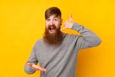 Kızıl saçlı, uzun sakallı, izole edilmiş sarı arka planlı bir adam.