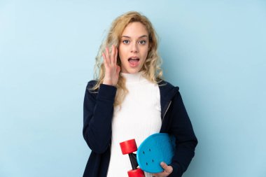 Genç sarışın kadın mavi arka planda izole edilmiş ve sürpriz jest yapıyor.