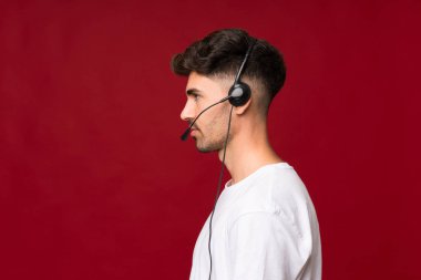 Tecrit edilmiş genç adam kulaklıkla çalışıyor.