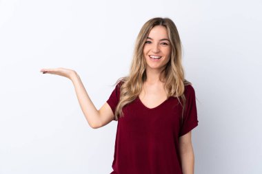 İzole edilmiş beyaz arka plan üzerinde genç bir kadın bir ilan vermek için avucunun içinde hayali bir alan tutuyor.