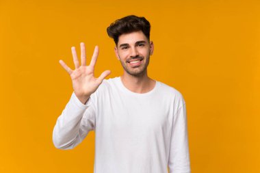 İzole edilmiş turuncu arka planda beş parmaklı genç adam var.