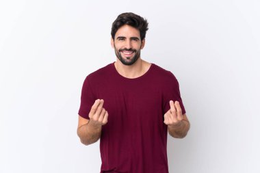 Soyutlanmış beyaz bir geçmişi olan, sakallı, yakışıklı genç bir adam para hareketi yapıyor.