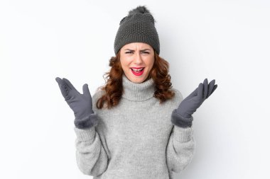 Kışlık şapkalı genç Rus kadın izole edilmiş beyaz arka planda mutsuz ve hayal kırıklığına uğramış bir şey tarafından.