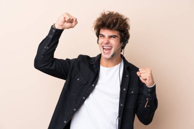 Tele pazarlamacı, izole edilmiş arka planda bir kulaklıkla çalışarak zaferi kutluyor.