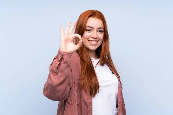 Rossa Adolescente Ragazza Isolato Sfondo Blu Mostrando Segno Con Dita — Foto Stock