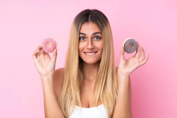 乌拉圭年轻女子 身披粉色背景 手持甜甜圈 — 图库照片