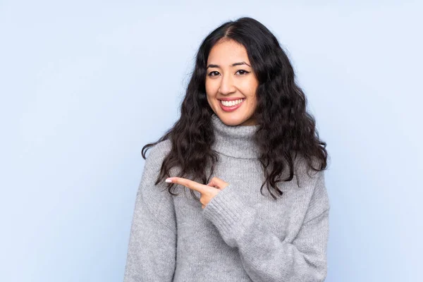 Spaanse Chinese Vrouw Geïsoleerde Blauwe Achtergrond Wijzend Naar Zijkant Een — Stockfoto