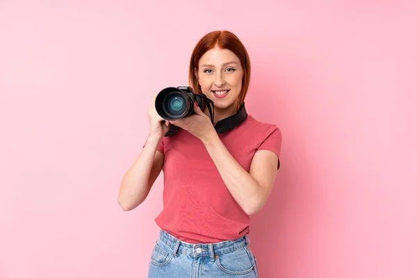 Genç Kızıl Saçlı Izole Pembe Arka Planı Olan Profesyonel Kameralı — Stok fotoğraf