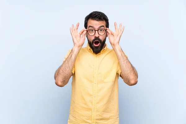 Jongeman Met Baard Geïsoleerde Blauwe Achtergrond Met Bril Verrast — Stockfoto