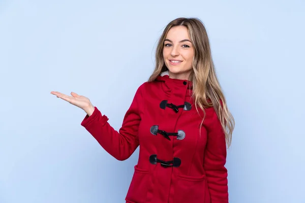 Giovane Donna Con Cappotto Invernale Sfondo Blu Isolato Tenendo Copyspace — Foto Stock