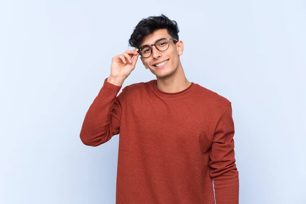 Mladý Argentinský Muž Přes Izolované Modré Pozadí Brýlemi Šťastný — Stock fotografie