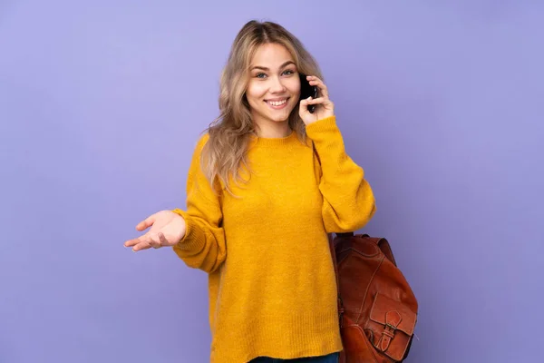 十代のロシアの学生の女の子は紫の背景に孤立誰かと携帯電話との会話を維持 — ストック写真