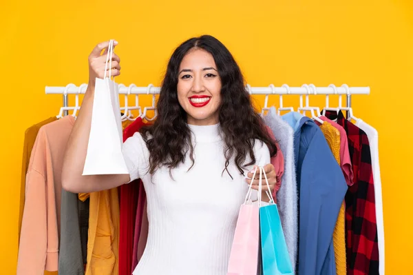 Mujer de raza mixta en una tienda de ropa y con bolsas de compras — Foto de Stock