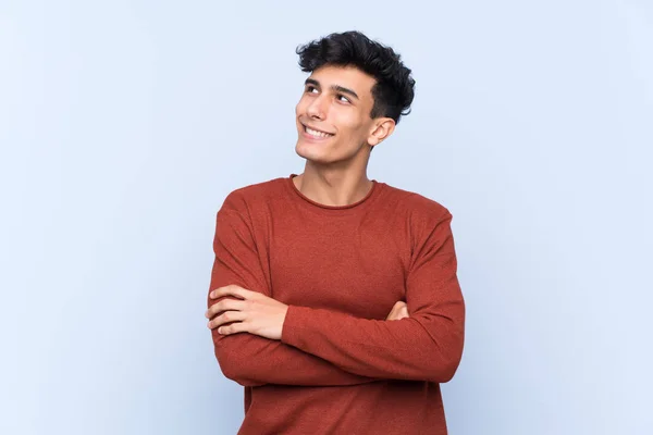 Mladý Argentinský Muž Přes Izolované Modré Pozadí Vzhlíží Usmívá — Stock fotografie