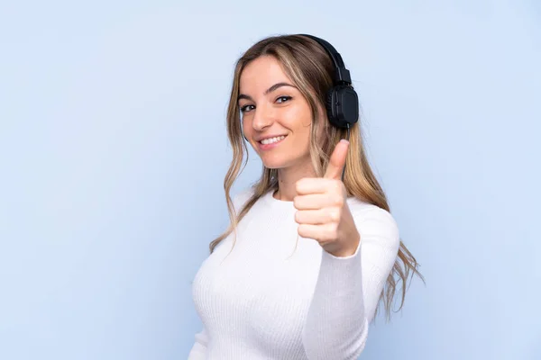 Jovem Mulher Sobre Fundo Azul Isolado Ouvir Música Com Polegar — Fotografia de Stock