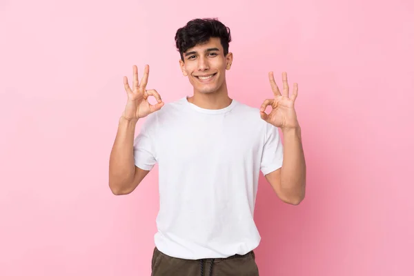 Jonge Argentijnse Man Geïsoleerde Roze Achtergrond Toont Een Teken Met — Stockfoto