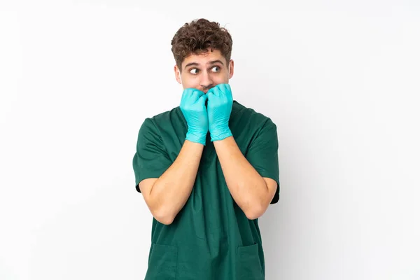 身穿绿色制服的外科医生被隔离在孤立的白色背景下 神经紧张 不敢把手放在嘴上 — 图库照片