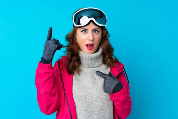 Narciarka Okularami Snowboardowymi Odizolowanej Niebieskiej Ścianie Zaskakującym Wyrazem Twarzy — Zdjęcie stockowe
