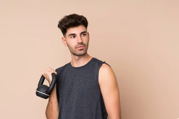 Joven Deportista Sobre Fondo Aislado Haciendo Levantamiento Pesas Con Kettlebell —  Fotos de Stock