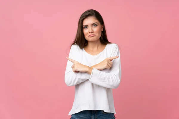 Mujer Joven Sobre Fondo Rosa Aislado Apuntando Los Laterales Que — Foto de Stock