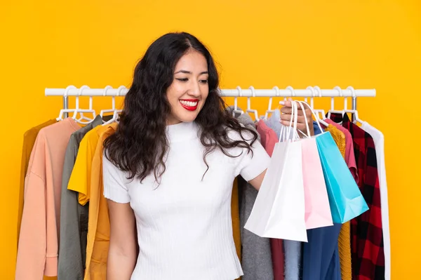 Smíšené rasy žena v obchodě s oblečením a s nákupními taškami — Stock fotografie