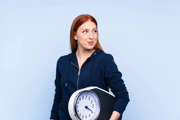 Young Redhead Sport Woman Isolated Blue Background Weighing Machine — Stock Photo, Image