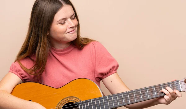 Ukrainian teenager girl with guitar over isolated background — Stock Photo, Image