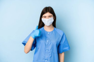 Genç dişçi kadın mavi arka planda aletleri tutuyor.