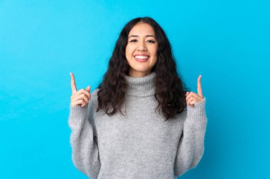 İspanyol Çinli kadın izole edilmiş mavi arka plan harika bir fikre işaret ediyor.