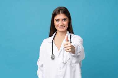 Doktor önlüğü ve başparmağıyla soyutlanmış mavi bir geçmişi olan genç bir kadın.