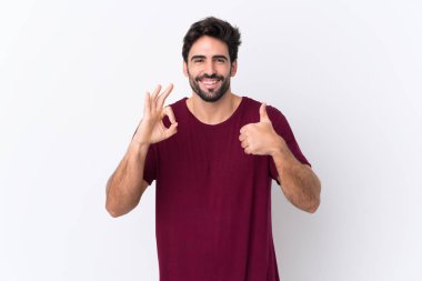 Sakallı, beyaz bir geçmişi olan genç yakışıklı bir adam işaret ve el hareketi gösteriyor.