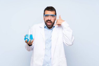 Genç bilimsel deney şişesi izole edilmiş arka plan üzerinde telefon jestleri yapıyor ve şüphe uyandırıyor