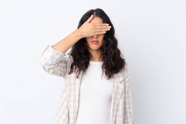 İzole edilmiş beyaz arka planda melez bir kadın gözlerini elleriyle kapatıyor. Bir şey görmek istemiyorum.