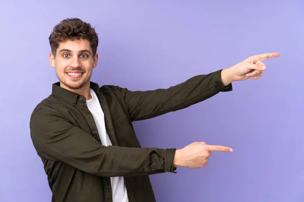 Caucasian Man Isolated Purple Background Pointing Finger Side Presenting Product — Stock Photo, Image