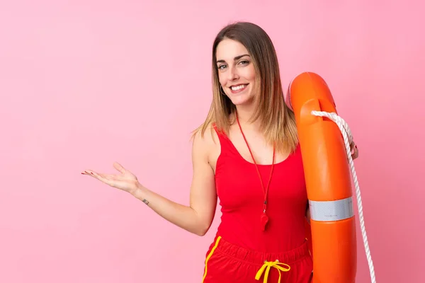 Lifeguard woman over isolated background holding copyspace imaginary on the palm
