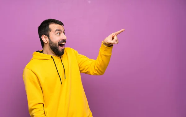 Bonito Homem Com Camisola Amarela Apontando Para Longe — Fotografia de Stock