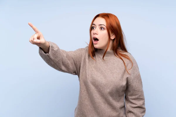 Ruiva Adolescente Menina Com Suéter Sobre Isolado Fundo Azul Apontando — Fotografia de Stock