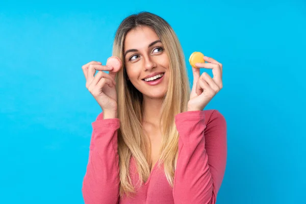 Jovem Uruguaia Sobre Fundo Azul Isolado Segurando Macarons Franceses Coloridos — Fotografia de Stock