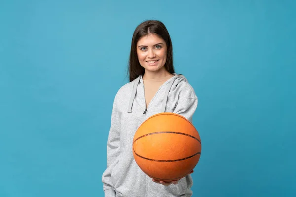 Genç Bir Kadın Basketbol Topuyla Izole Edilmiş Mavi Arka Plan — Stok fotoğraf