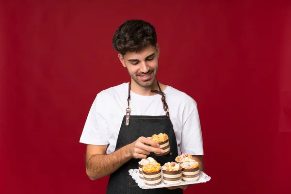 Jongeman Geïsoleerde Achtergrond Met Mini Cakes Verrast — Stockfoto