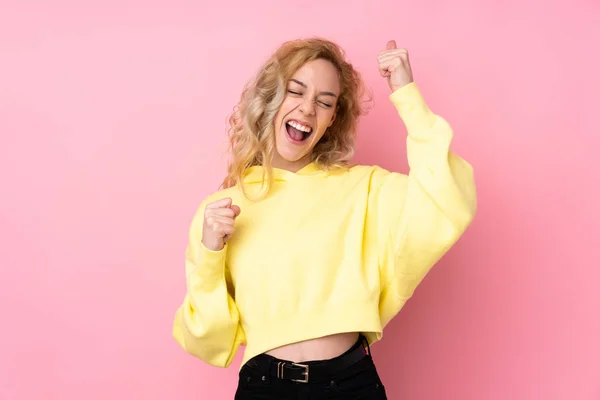 Jovem Loira Vestindo Uma Camisola Isolada Fundo Rosa Comemorando Uma — Fotografia de Stock