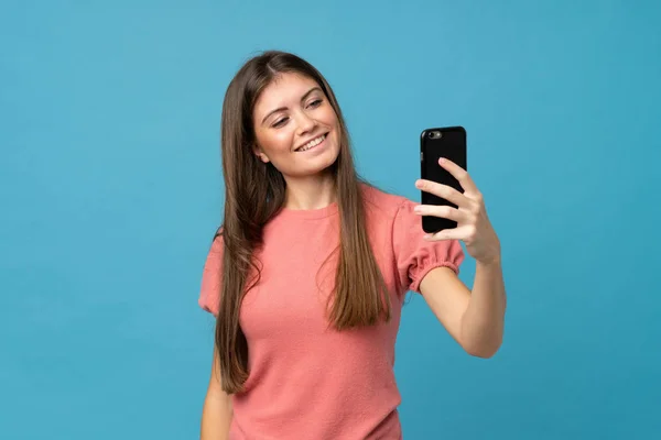 Mujer Joven Sobre Fondo Azul Aislado Tomando Una Selfie Con — Foto de Stock