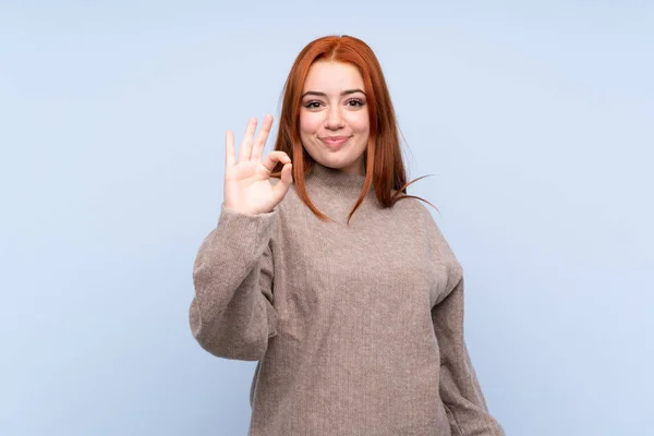 Rossa Adolescente Ragazza Con Maglione Isolato Sfondo Blu Mostrando Segno — Foto Stock