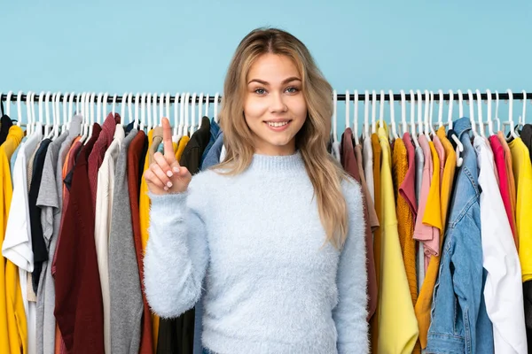 Teenager Ragazza Russa Acquistare Alcuni Vestiti Isolati Sfondo Blu Mostrando — Foto Stock