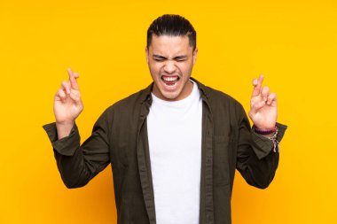 Asyalı yakışıklı adam sarı arka planda tek başına zaferi kutluyor.