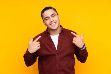 Asyalı yakışıklı adam sarı arka planda izole edilmiş.