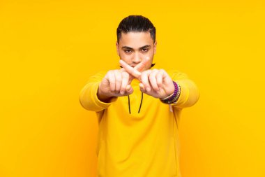 Asyalı yakışıklı adam sarı arka planda izole edilmiş. Parmakları olan dokuz kişi saydım.